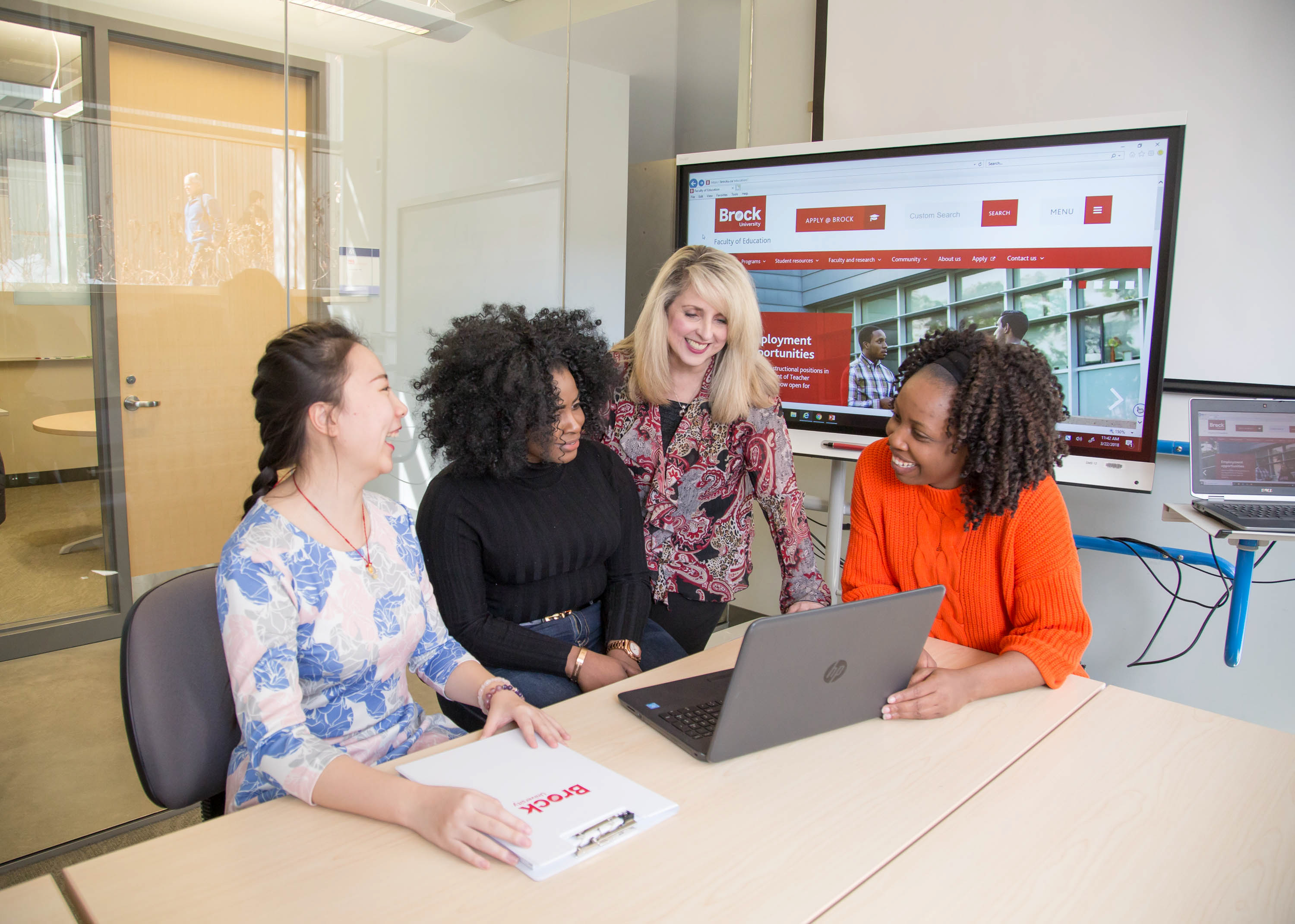 This image includes 4 people engaged in discussion in a collaborative space in the Faculty of Education building