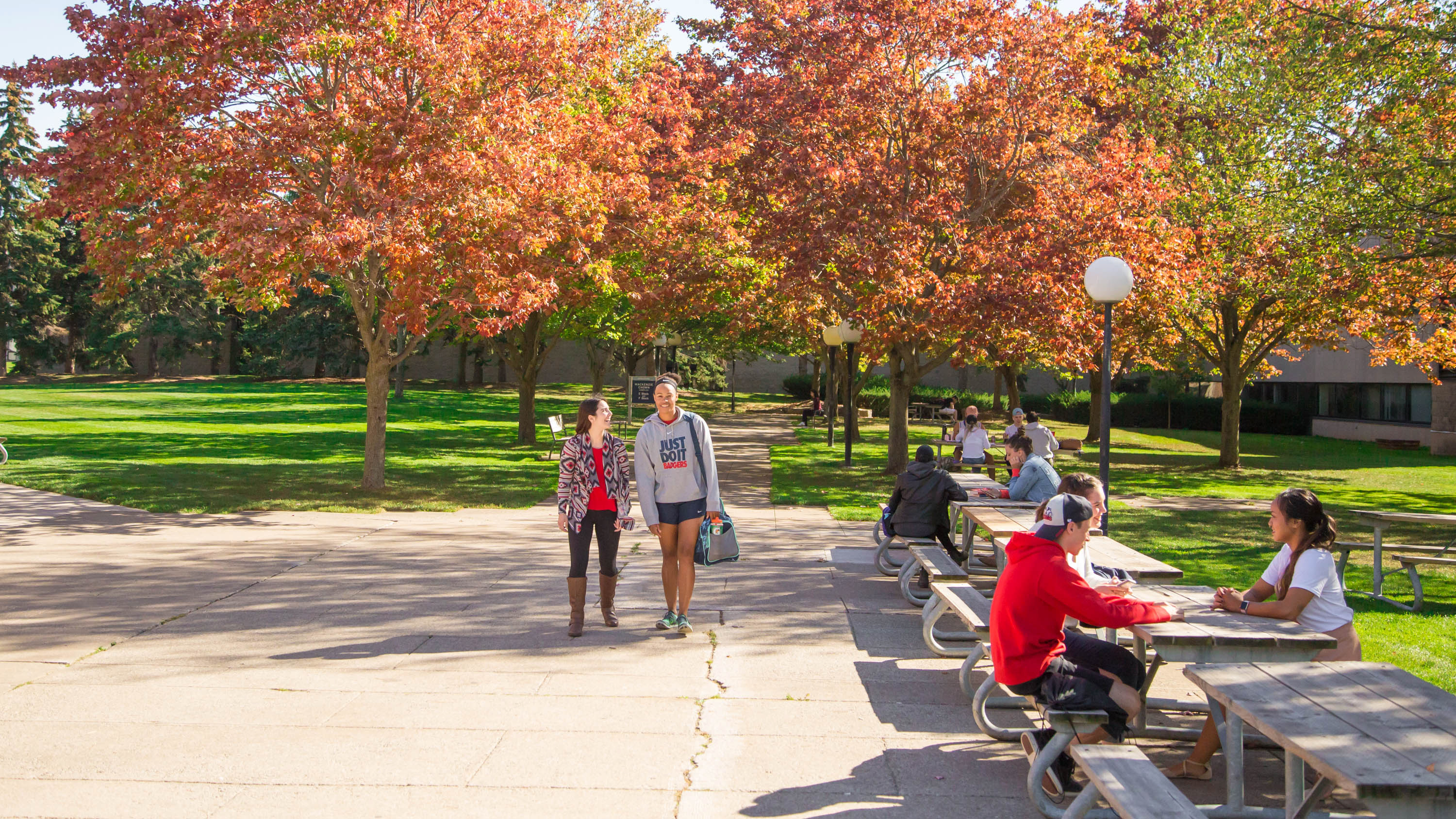 This image displays a pathway with pedestrian traffic in front of the Mackenzie Chown Complex on Brock University?s St. Catharines campus.